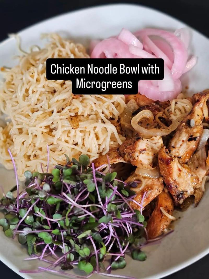 Chicken noodle bowl served with purple radish microgreens on the side